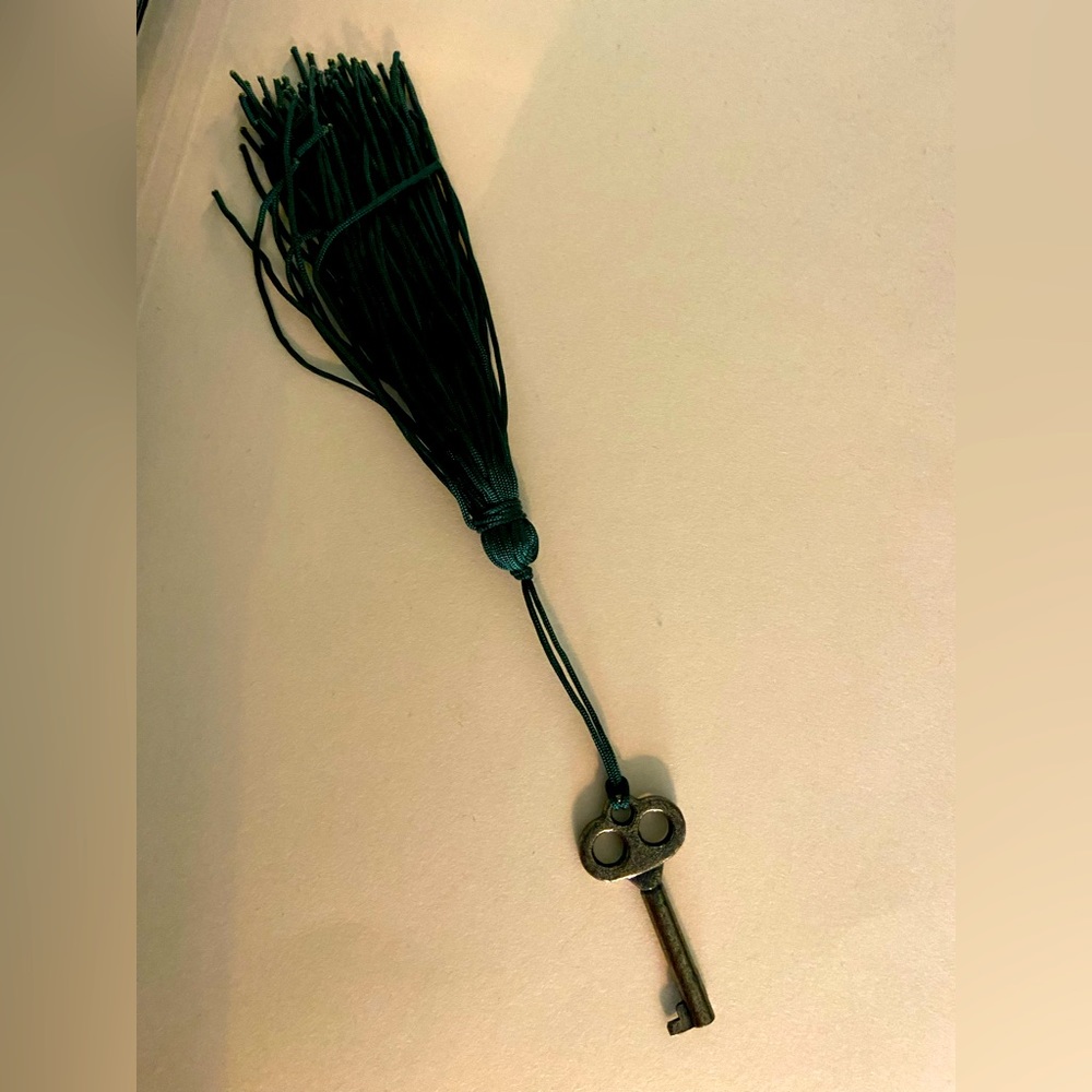 Jewelry cabinet/watch cabinet skeleton key with green tassel.